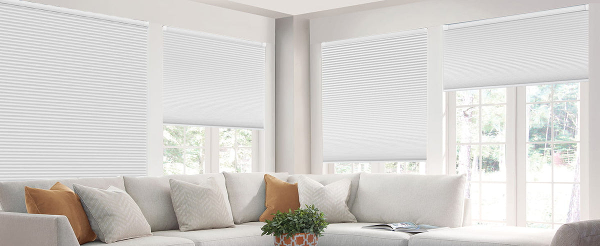 White cellular shades behind a living room sofa