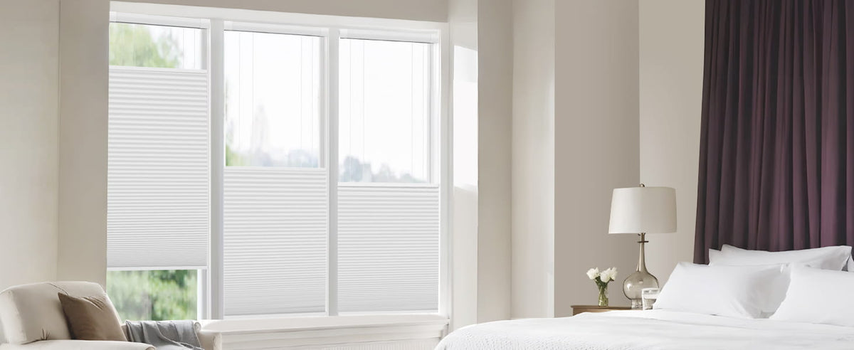 Top-down bottom-up cellular shade partially covering a bedroom window