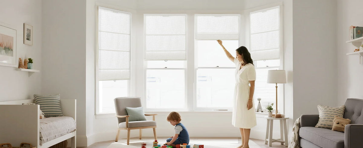 Woman adjusting a cordless Roman shade while a child plays nearby