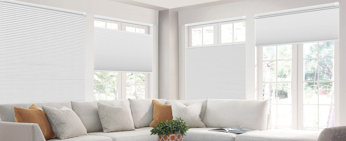 White cellular shades behind a living room sofa