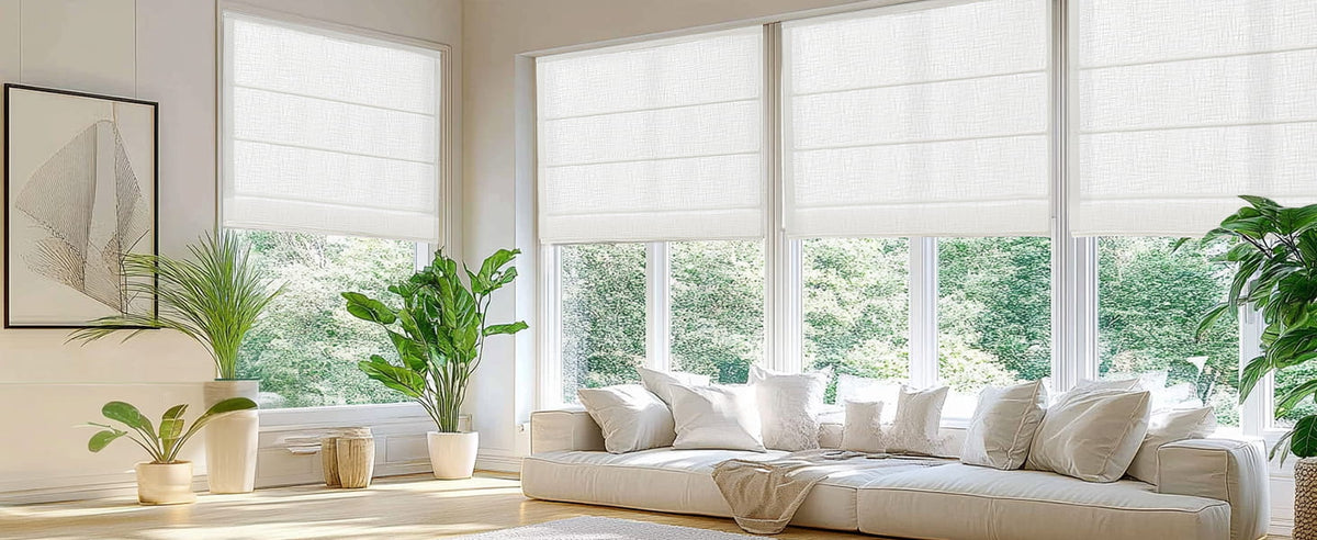 White Roman shades in a bright living room with plants