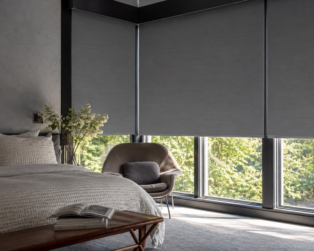 Gray roller shades in a modern bedroom with large floor-to-ceiling windows