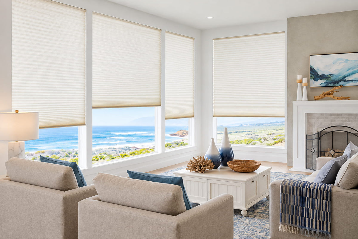 White window shades in a coastal living room with ocean views and light sofas.