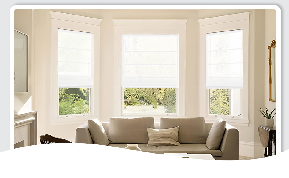 White Roman shades behind a sofa on bay windows