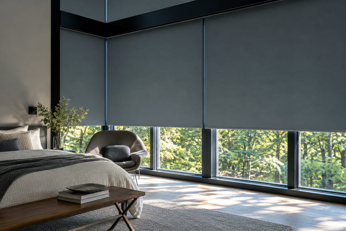 Dark roller shades across floor-to-ceiling bedroom windows, with garden views below.